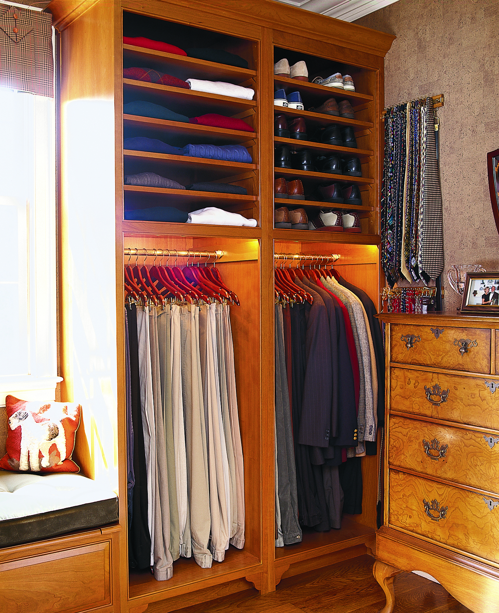 A closet design that has two hanging sections and then shelves above it for shoes and folded clothes.