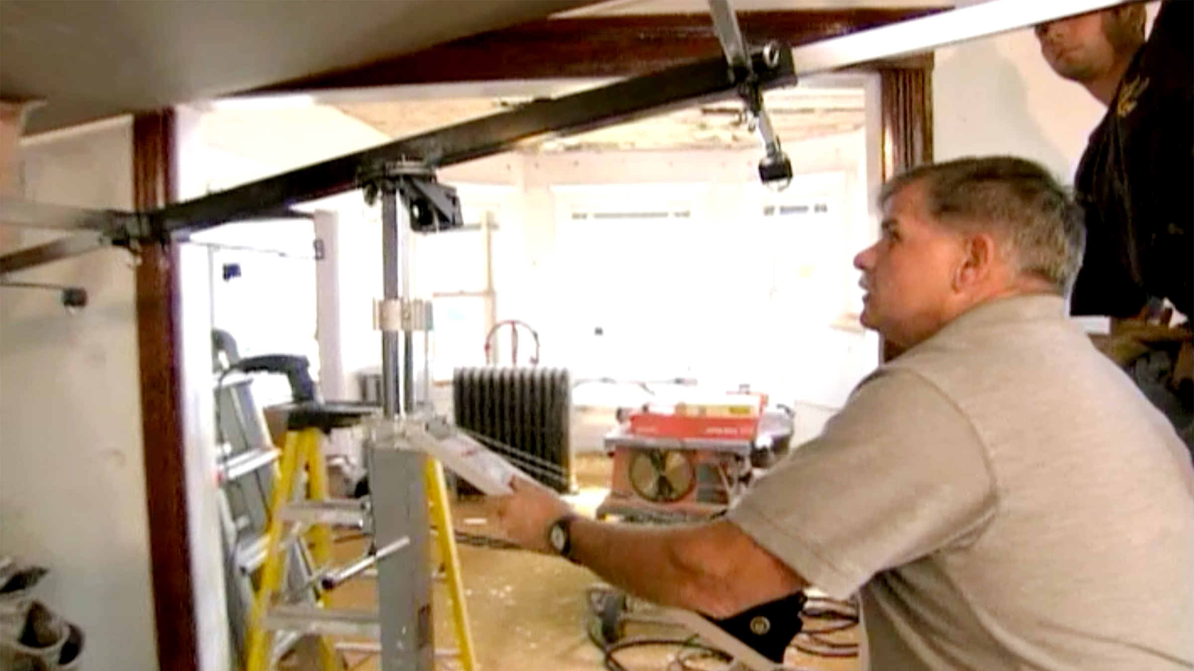 Tom Silva installs drywall on a ceiling